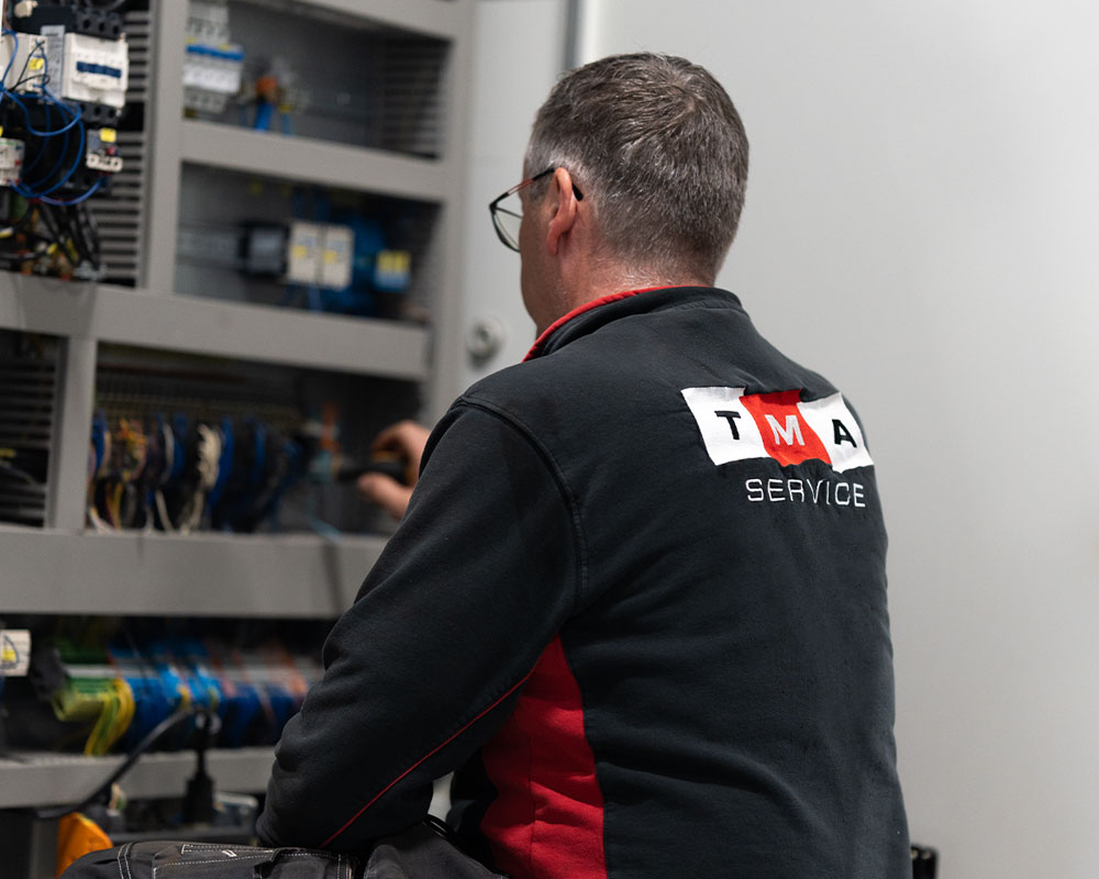 Medarbetare som inspekterar och åtgärdar fel i styrskåp industrielektronik